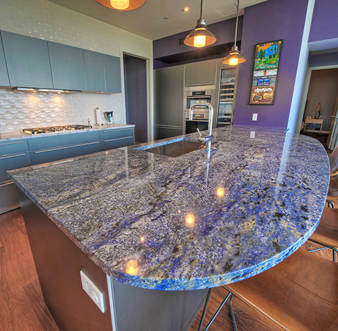 Blue Bahia granite Island is the colorful centerpiece of this La Vaca Hotel Suites kitchen, with Silver Storm marble perimeter countertops as an elegant, neutral color contrast.