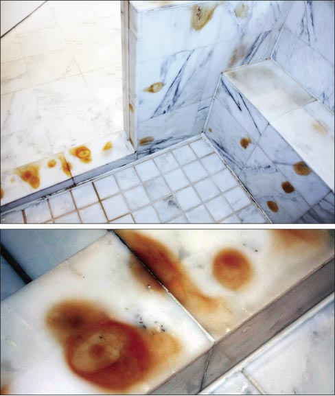 The white marble shower had these brownish-yellow spots.