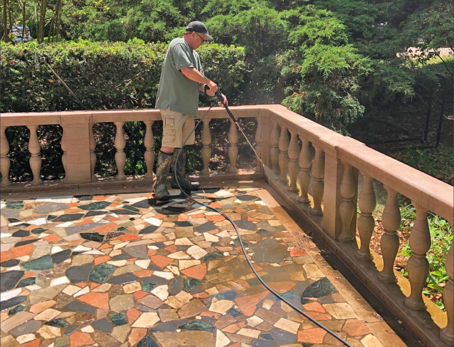 Pressure washing a quilted marble patio and stone balustrade.  Care must be taken to avoid blasting out the mortar in installations, especially old ones. Here, I’m using a 3,500 psi pressure washer.