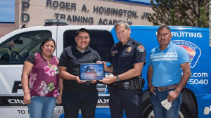 Albuquerque officials celebrated Jose Nunez’s decision to return the money. He holds a plaque presented by Police Chief Mike Geier. They are flanked by Nunez’s parents, Carmen Romaniz and Jose Nunez Juarez.