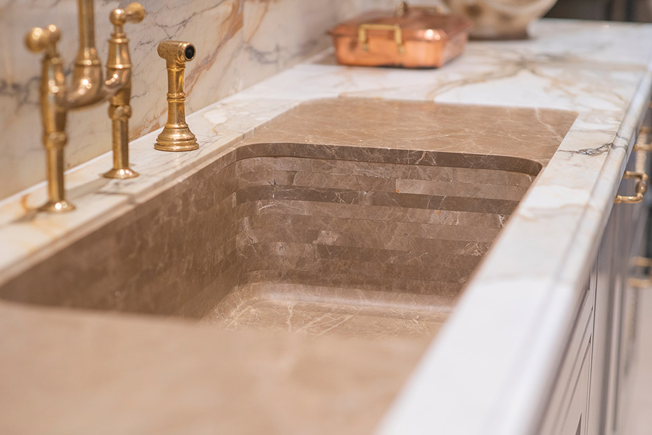 Detail of the sculpted sink, layered with different marble slabs in Calacatta Macchia Vecchia