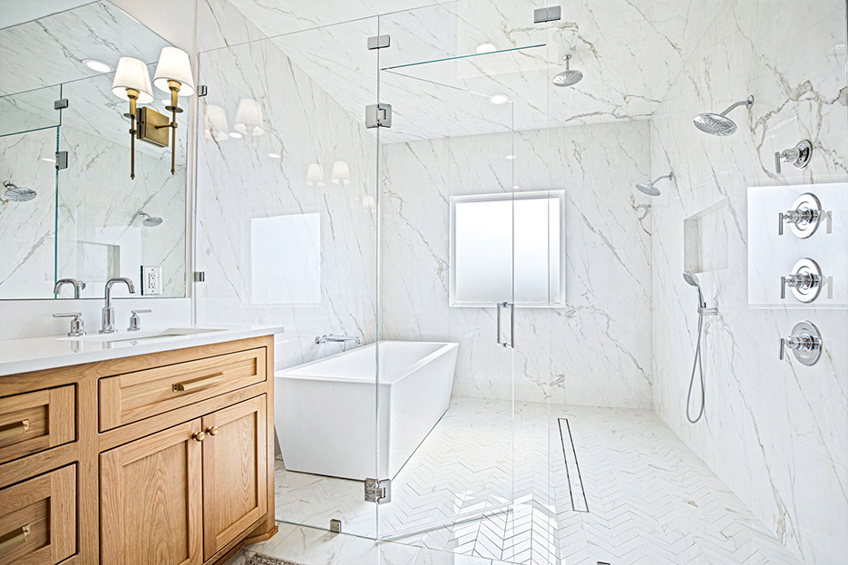 This floor-to-ceiling remodel utilizes large format porcelain in ways that marble cannot match.