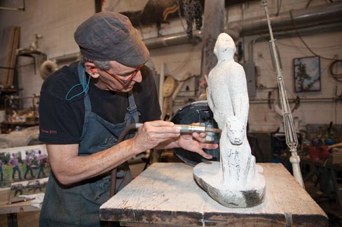 Wheelwright lovingly puts his hand-eye skills into action as “Man and Dog,” a current project in granite, receives the final touches of the Maestro.