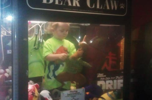 In this April 14, 2014 photo provided by Rachelle Hildreth, a 3-year-old boy plays with stuffed toys inside a claw crane game machine at a bowling alley in Lincoln, Neb. Police say a 24-year-old woman called 911 that Monday afternoon because her son was missing from her apartment. Authorities say the toddler was reunited, unharmed, with his mother after employees found him inside the coin-operated game. Photo: Courtesy Rachell Hildreth, AP