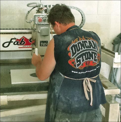 Jeremy Speegle operates the shop’s Fab King with a template to make a replacement Disney fountain tile.