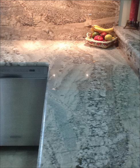 Bordeaux granite countertops with matching backsplash and sills are used throughout this residential kitchen renovation.