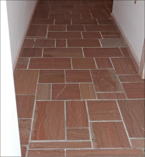 The same entryway floor with the lippaage removed, after honing and polishing.  The beauty of this stone floor shines through, again – and the property value has also gotten a boost.