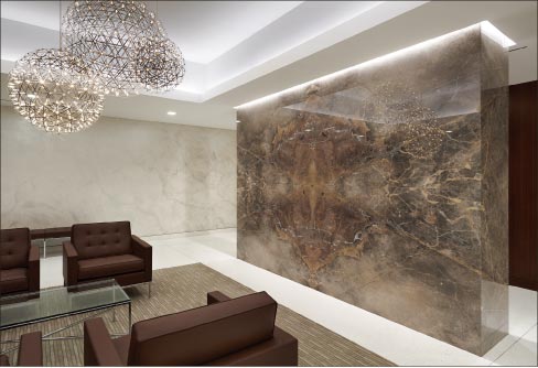 The Pickwick building lobby in Greenwich, Connecticut features a top-lit, bookmatched  Fior D’ Bosco marble wall, separating the space between the sitting area and elevators.