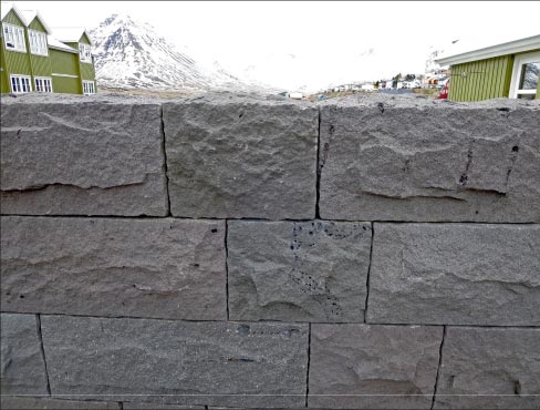 At first glance this harbor retaining wall looks like ordinary modular concrete block. But a closer inspection reveals that it’s actually lava rock. The telltale sign is the presence of Swiss-cheese-like holes, caused by gases in the lava.