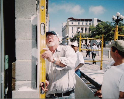 Lenny Rogers checks the vertical alignment on a façade job.