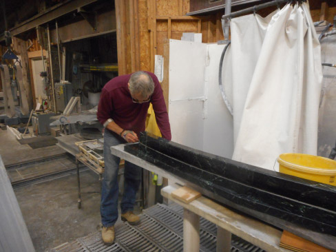 Wilson hand finishing Vermont Verde Antique marble radius scum gutters, for the Neptune Pool.