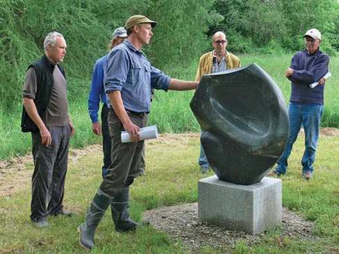 Hugh Lassen speaks to the crowd about his sculpture “Seed Form,”  made from Glacial Erratic, during the trail tour.