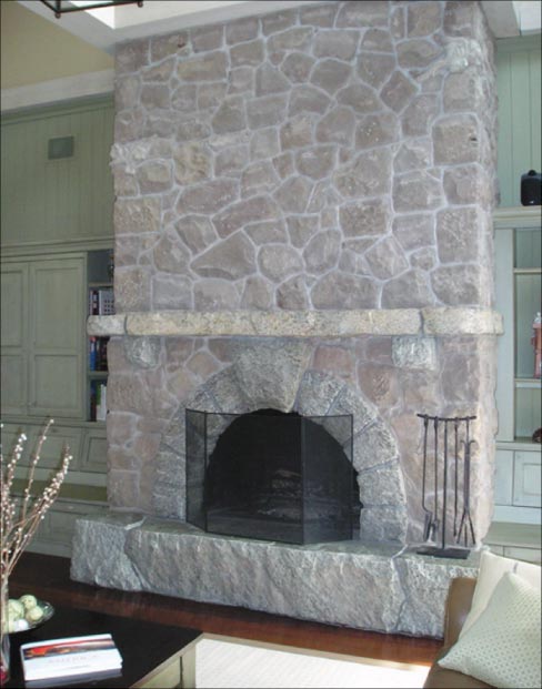 “Made with local gray granite and sandstone, the hearth, surround and mantle were cut and split and from one boulder that a geologist tested and said was 1.2 billion years old,” explained Mike. “The arch consists of two bookend split stones with faux mortar joints, and a keystone with a grain that runs consistently through all the stones around the arch. For ‘kicks and giggles’ I added a hand carved, local sandstone vine of ivy which the customer loved.”