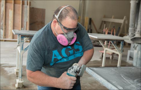 Below: Long-time AGS fabricator Eduardo fine-tunes an edge with a Makita grinder before wet-polishing. He has been with the Rogers from the beginning.