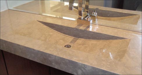 Lagos Blue custom vanity sink. “The curving sink the client wanted required us to laminate seven layers of 3cm Caesarstone, and then grind out the bowl to meet the design specification for this sink!”