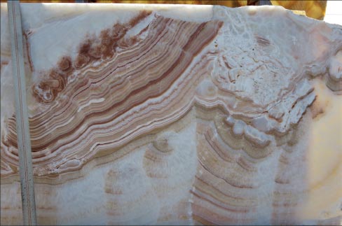 This White Onyx slab beautifully illustrates the typical, intricate crystals of calcite, and iron-rich color banding.