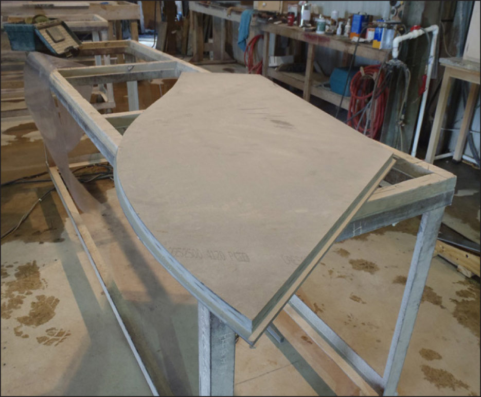 Custom-shaped top constructed with box seams. The excess material is removed with a grinder.