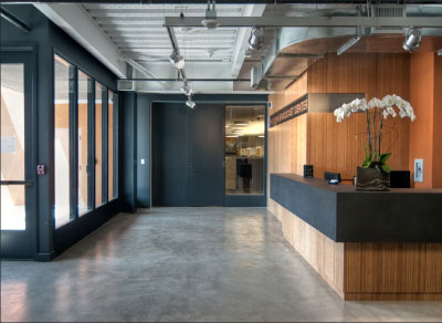 PaperStone waterfall reception desk. Photo courtesy Southern California Public Radio, Pasadena, 89.3 FM.  Photography by www.nilstimm.com. Architects Chu+Gooding Architects with Russ Berger Design Group