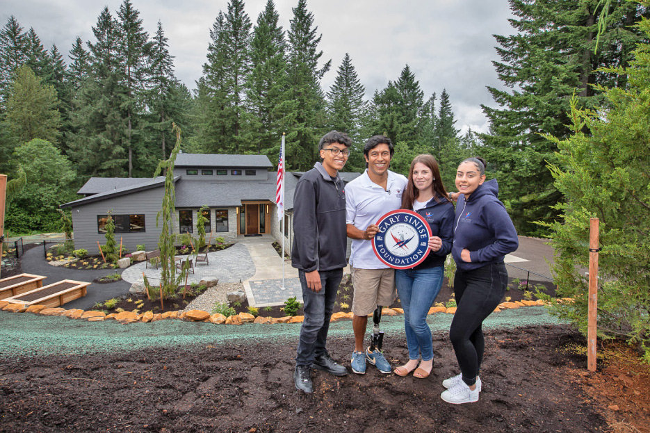 US Army Staff Sergeant Rico Roman and family in front of their new home.