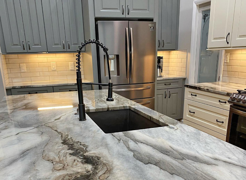 The flowing veins in these Brazilian Aurelius marble countertops make a bold statement against neutral-toned Wellborn cabinets. 