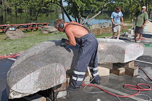 Symposium sculptor Ton Kalle of the Netherlands concentrates on wet polishing – while also working on his tan in Maine’s pure morning sun