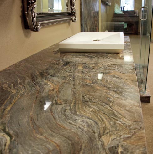 En suite bath features a long sweep of Pompeii granite vanity top with matching shower cladding.