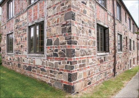 The right side entrance and corner view reveals the fine details of stone, brick and wood used in many Tudor Revival structures at the time. Built using local quarried stone and wood shipped from the west coast, the bricks are said to have come from Portland, Maine. Terracotta roof tiles, copper gutters, and down spouts conclude the charm of the “Tudor-style.”