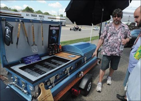 Nightmare Cruisers hearse club president Steve Frey, left, shows off his “Open Casket Bar and Grill” during the inaugural Scream Cruise, Hosted by the Nightmare Cruisers Hearse Club.