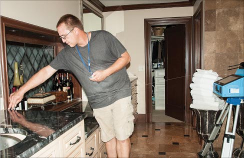 Trenton Hayes sets measuring points for a two-level marble vanity using a Proliner Digital Templating system.