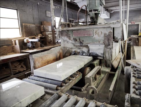 “We also have an well-used Savage Face Polisher. Unfortunately, no one can date when this machine was built. Suffice it to say that it is pretty old, as it was purchased from the Vermont Marble Company.” Here, a large cut-to-size job is being staged: custom windowsills with a honed finish.