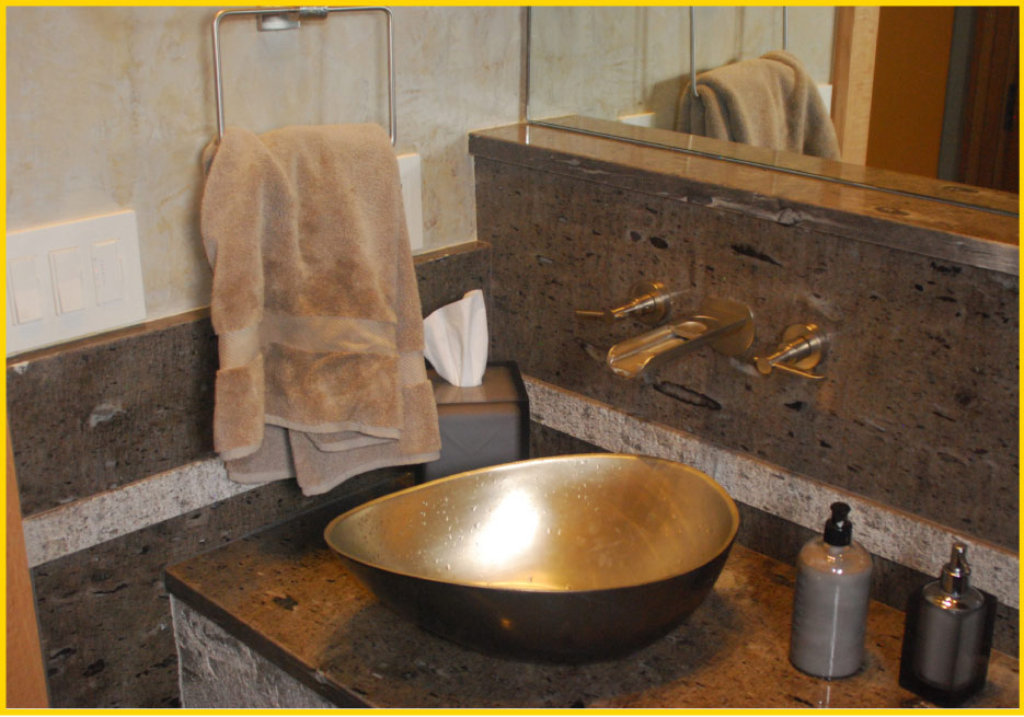 Aspen granite from Brazil, with a combination of leather finish and a contrasting band of bush hammered Aspen granite stripe and apron, complements this vanity and copper vessel sink.