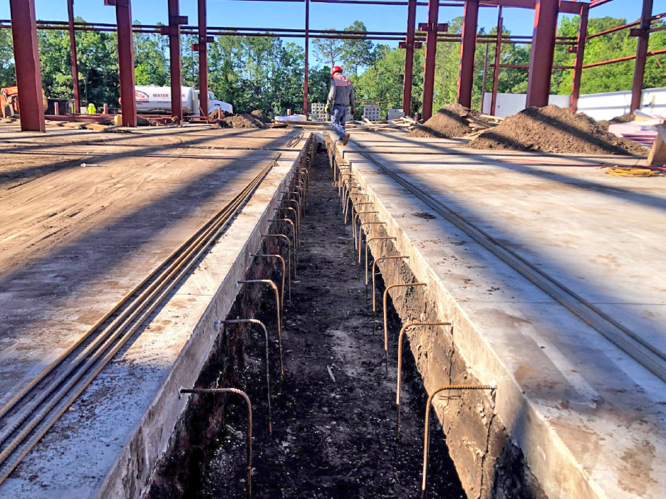 Trench with steel reinforcement tied into new shop floor with epoxy.