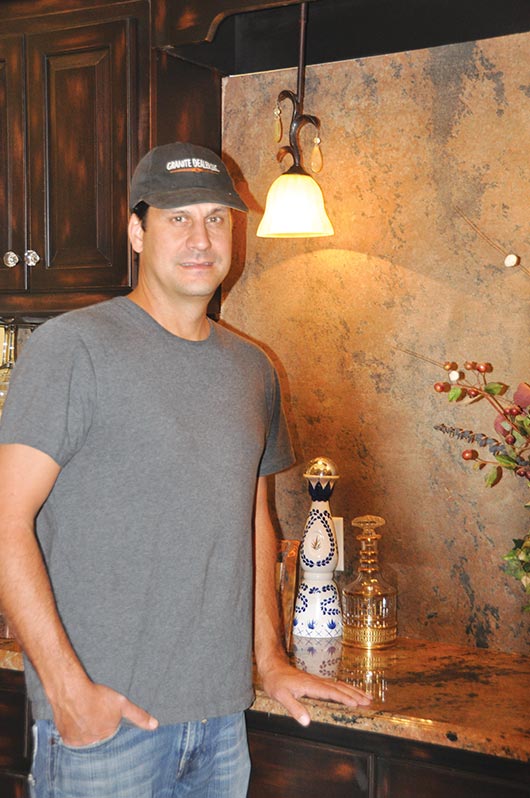 Brian Hodges, owner of Granite Dealer in Memphis, TN, stands in front of his concept for bar backsplashes