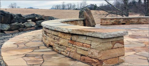 The seating walls are 18 inches tall. They are built using drystone construction methods, though the caps are mortared in place for stability.