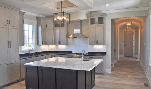 This model kitchen in Carmel, Indiana by Dale Woodall Custom Homes features Black Pearl counters and Calacutta Esmerelda for the oversized 68˝ x 80˝  island. “Our biggest goal has always been a one week turnaround time,” explained Josh Spencer, Stone Spectrum LLC Operations Manager.