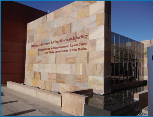 The UNM Cancer Treatment and Research Facility entrance wall includes a water feature.