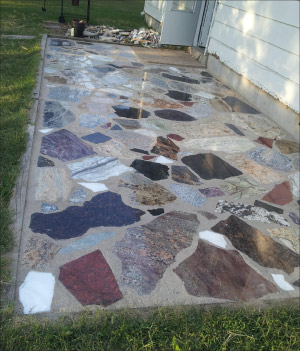 Mixed granite and marble scraps in irregular shapes and sizes give this colorful patio floor a fieldstone look. Recycling and repurposing can save millions of tons of good stone from being dumped in waste piles and landfills.