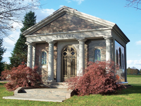 Stuart Mausoleum: Variegated Rainbow granite, one of the hardest of its kind in the world, is an inspired choice for this regal Neo-classical mausoleum. The sanded Doric columns, architrave and roof contrast beautifully with the polished granite walls. Palladian accents, including the arched windows and door, harmonize with the columns to form a complete and elegant architectural statement.  