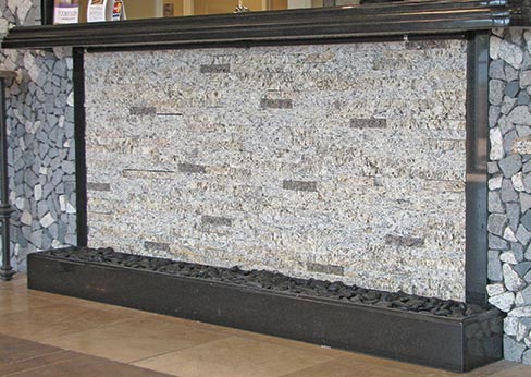 Fig. 4.  This front desk counter of tumbled and stacked stone incorporates a water feature.