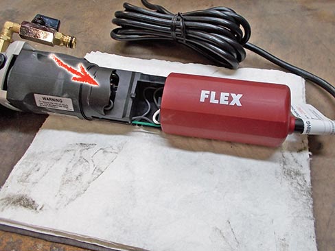 Fig. 1. Carbon brush locations vary on different tool models and makes, but all are usually located under a protective housing, accessible by removing screws on the cover. The above example shows the Flex LW-1503 with cover/handle removed; the brushes lie behind the protective inner cover indicated by the red arrow.