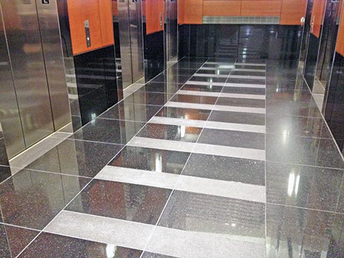 Flamed granite tiles interspersed with polish finished tiles cause Wiley to have to resurface hone/polish each tile by hand, in the lobby and matching tile in the elevators, as well.