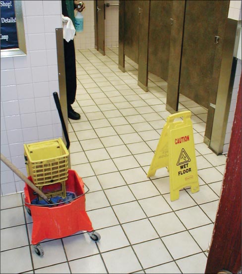 Maintenance on a ceramic tile floor. Don’t forget the Caution! Wet Floor signs!