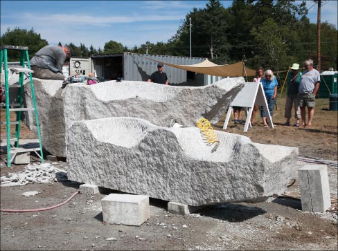 “Artists are allowed to choose the design and size of their project and are taken to a variety of local quarries and pits for the final choice of cubic stone for their project. As a rule, granite is the standard material used, but some artists choose to utilize basalt boulders or other glacial erratics,” explained Schoodic Art Director Jesse Salisbury. Washington State artist Robert Leverich is shown here carving for the town of Castine, Maine.