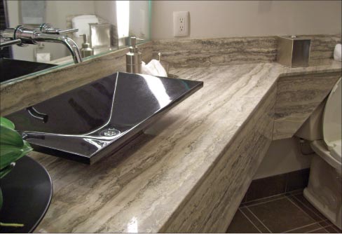 Seams are inevitable when your layout includes matching up a running backsplash around an angled surface, like this Silver Travertine vanity. The challenge then is making a smooth seam and matching the flow of the grain – and educating the customer on the options. 