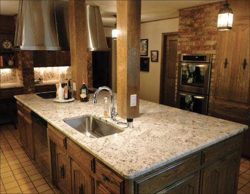 Granite kitchen island is made of about one and a half slabs, expertly seamed and joined near the center sink line. Full-height backsplashes are also featured in this traditional-styled  kitchen.