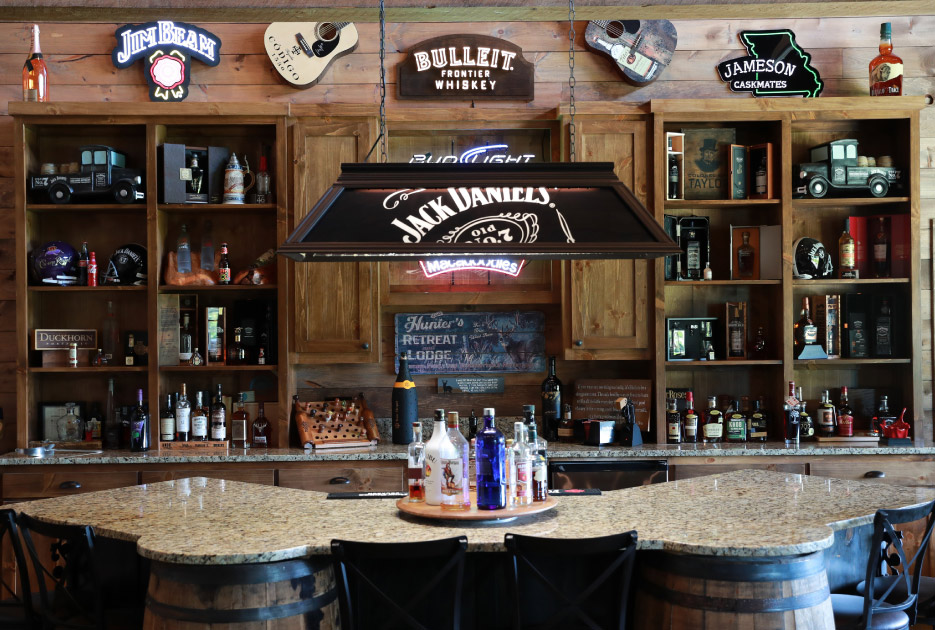 Non-rectangular is no problem for Restoneovation. New Venetian Gold island and per- imeter, with an impressive radius that matches the shape of barrels is the focal point of this man cave bar area.  Authentic oak barrels form the platform for this custom piece, personalized for the client.